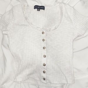 Very soft material! It also has lace. Brown and creams buttons. It fits small.